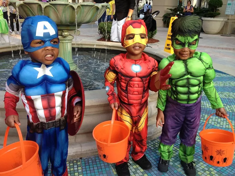 Image: three li'l trick-or-treaters dressed in superhero costumes