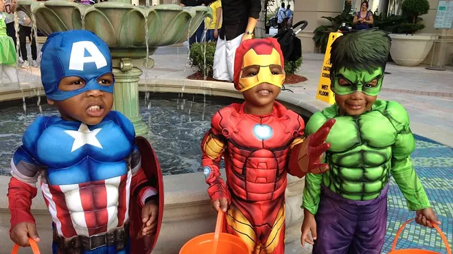 three li'l trick-or-treaters dressed in superhero costumes