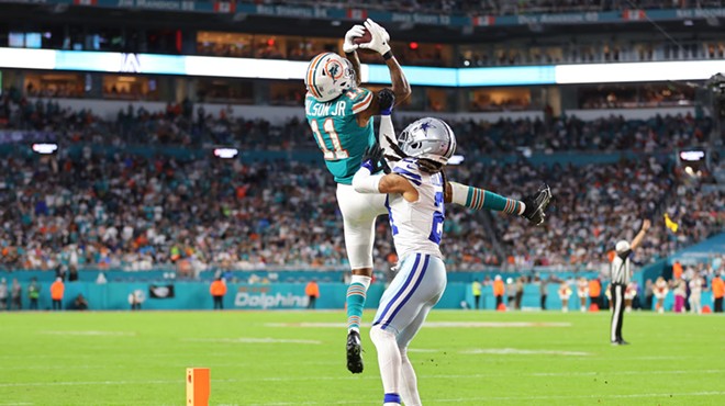 Miami Dolphins player leaps at the edge of the endzone to retrieve a pass