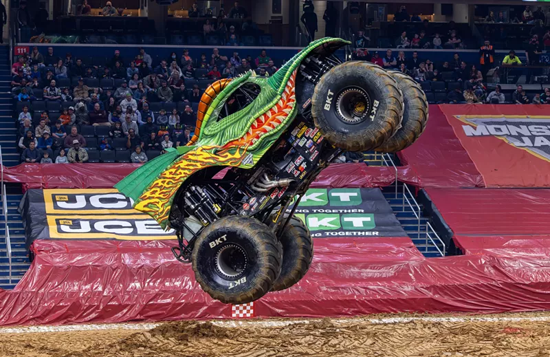 Image: a monster truck painted like a dragon flies through the air