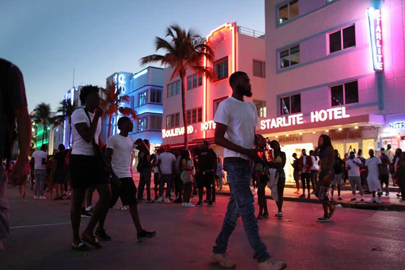 Spring breakers stroll along Ocean Drive.