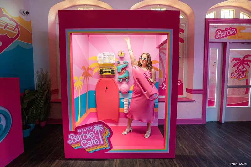 Image: A woman takes a photo at a Malibu Barbie Cafe pop-up.