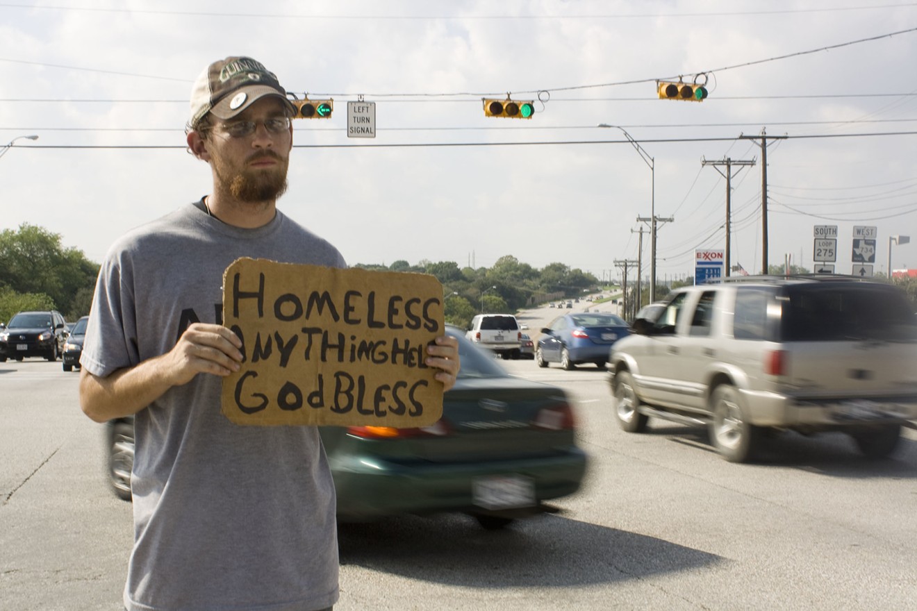A Texas man holds a sign while panhandling.