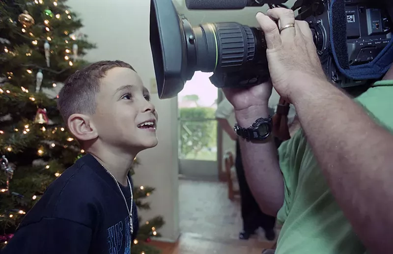 Image: Elián González smiles for TV cameras.