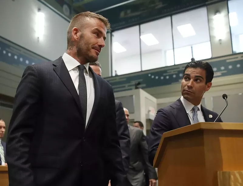 Image: Miami Mayor Francis Suarez looks on as David Beckham arrives for a meeting at Miami city hall in July 2018.