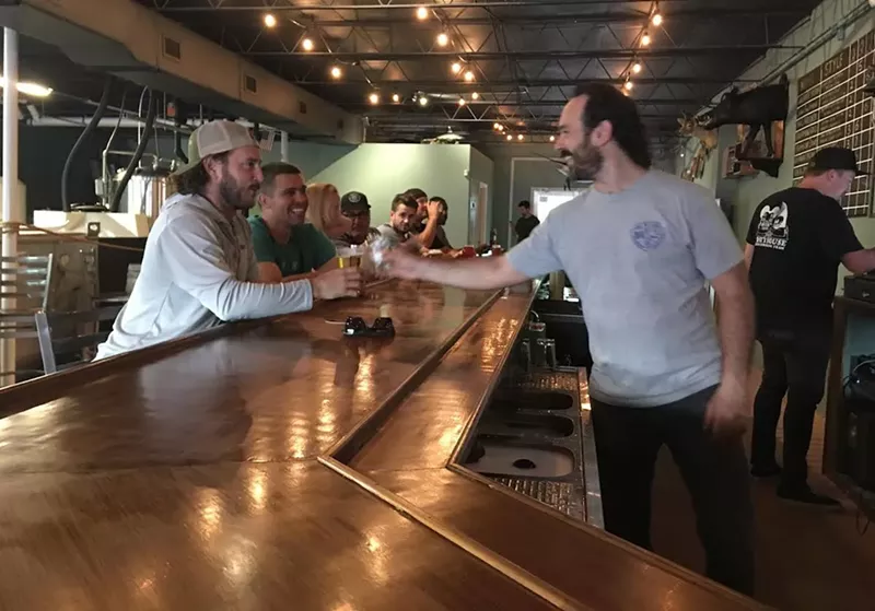 Image: Invasive Species brewer and cofounder Phil Gillis greets patrons on Monday, July 17.