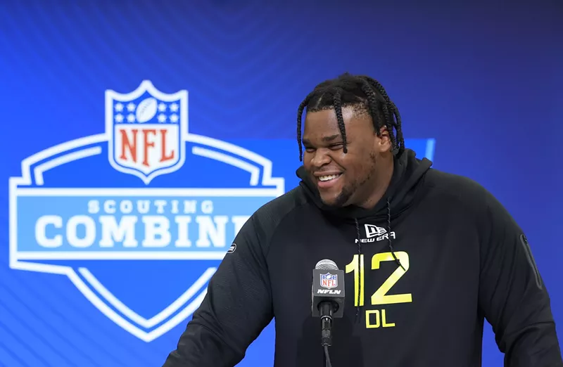 Image: Kenneth Grant #DL12 of Michigan, dreadlocked and smiling, speaks to the media during the 2025 NFL Combine at the Indiana Convention Center on February 26, 2025