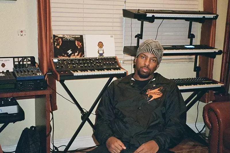 Image: Justin Wiggins sitting in a chair in his studio