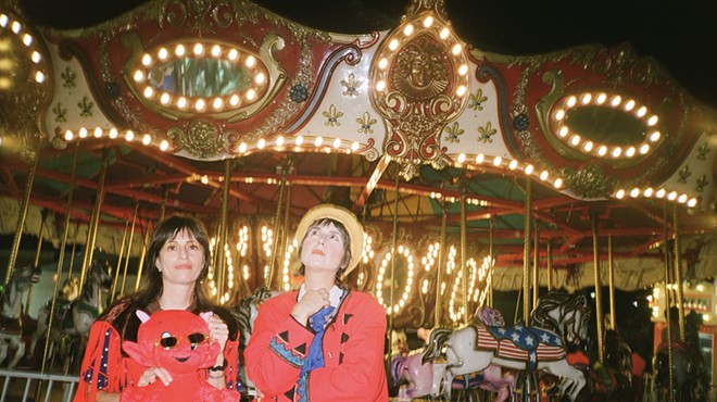 Las Nubes poses in front of a carousel