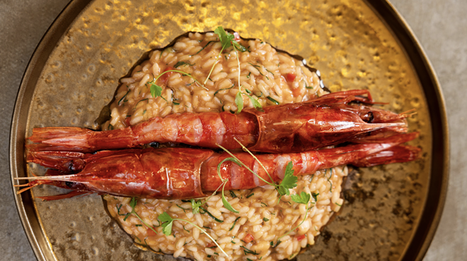 A rice dish with prawns in a gold setting