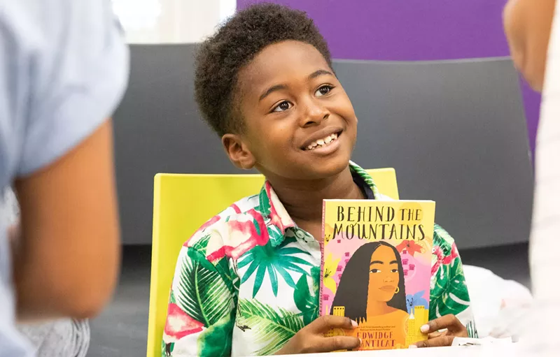 Image: A young reader and his book during the 2022 Little Haiti Book Festival.