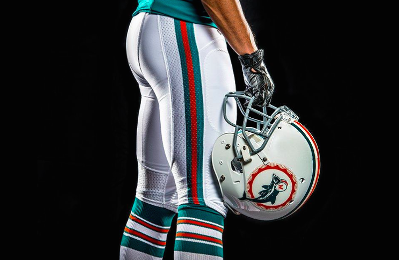 Image: detail showing a Miami Dolphins throwback helmet and uniform pants