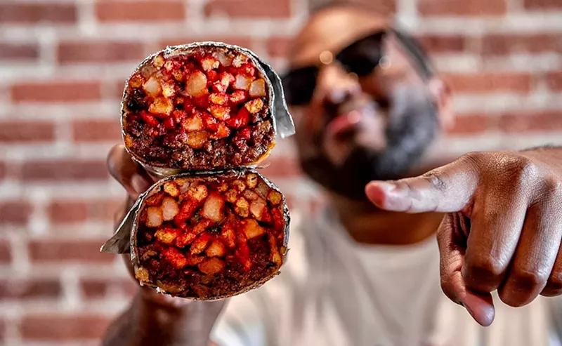 Image: Man vs Fries founder William Bohnorst shows off a French fry-stuffed "SoCal Burrito."