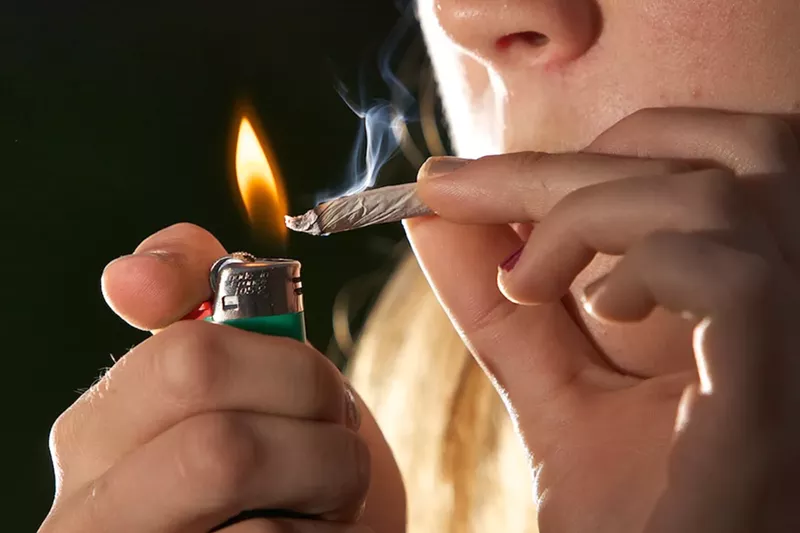 Image: A woman lights a joint