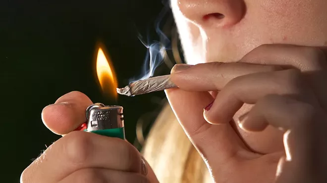 A woman lights a joint
