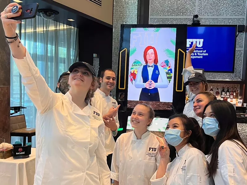 Image: FIU students pose with Cecilia, the robot bartender.