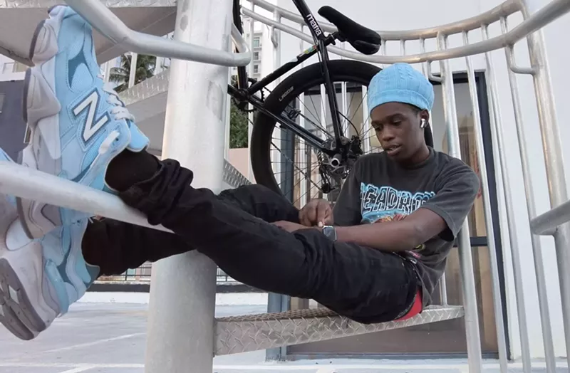 Image: Bicycle stunt rider Frank Sands in repose in Miami, with his bike in the background
