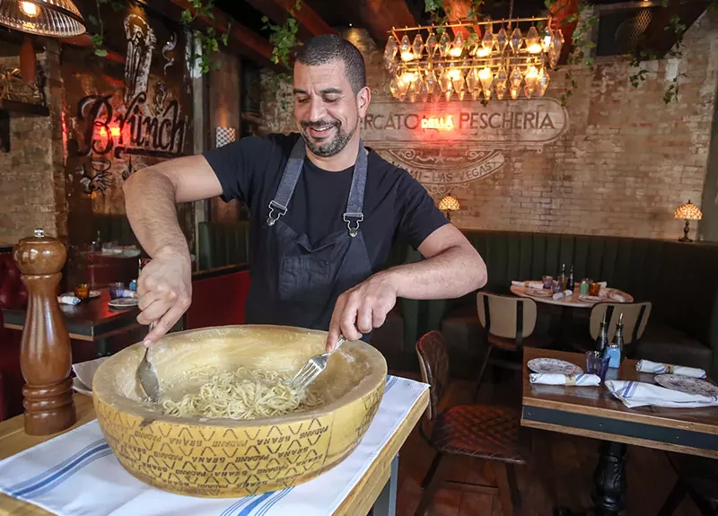 Image: Mercato Della Pescheria corporate chef Alex Martinez makes cacio e pepe in a wheel of Pecorino Romano cheese.