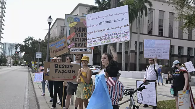 Protesters hold signs in West Palm Beach