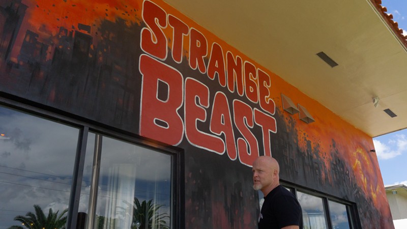 Muralist Derek Wilson stands in front of Strange Beast Brewery.