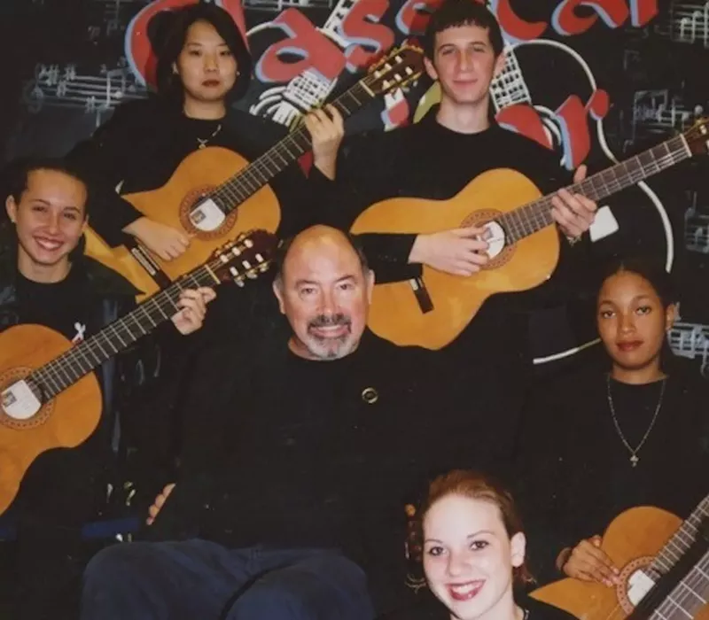 Image: Teacher Doug Burris in a wheelchair surrounded by students