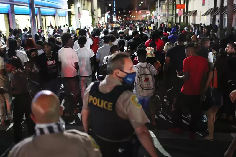 Image: People leave the area as an 8pm curfew goes into effect on March 21, 2021, in Miami Beach, Florida. College students arrived in the South Florida area for the annual spring break ritual, prompting city officials to impose an 8pm to 6am curfew as the coronavirus pandemic continued. Miami Beach police reported hundreds of arrests and stepped up deployment to control the growing crowds.