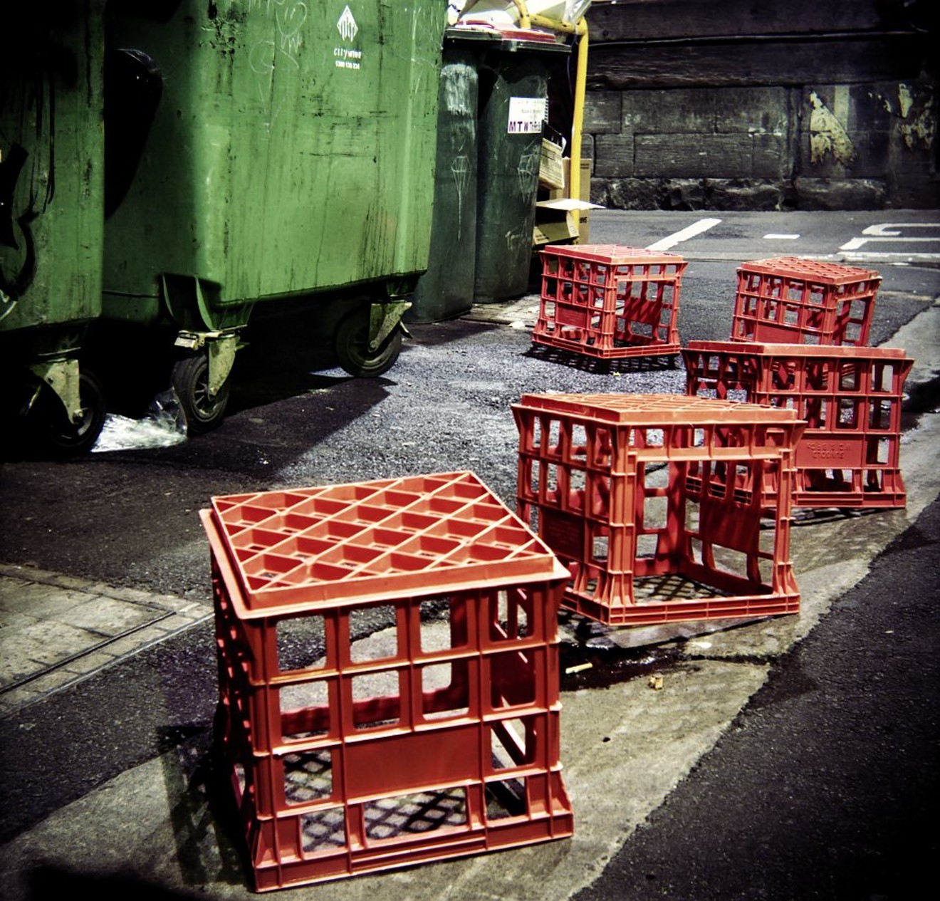 Dairy crates near a dumpster.