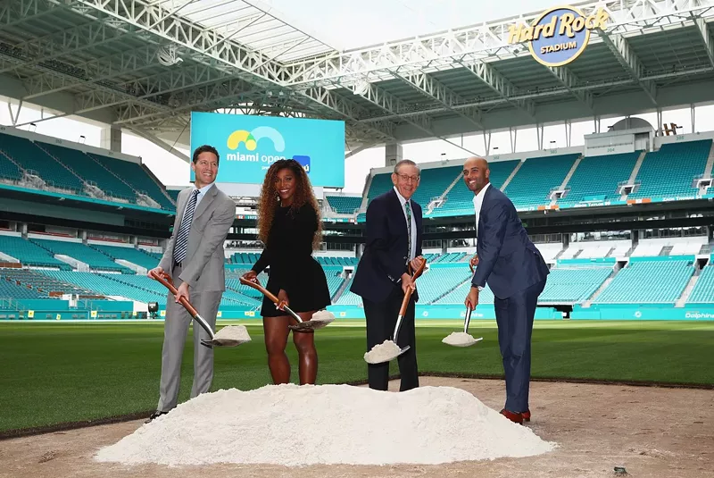 Image: Mark Sharpiro, WME/IMG Co-President; Serena Williams; Stephen Ross, Miami Dolphins owner; and James Blake, tournament director pose at Hard Rock Stadium in a groundbreaking ceremony for the future home of the Miami Open tennis tournament
