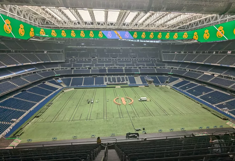 Image: a 2024 view of the retractable roof, playing field, and stands at the newly remodeled Estadio Santiago Bernabéu in Madrid, Spain