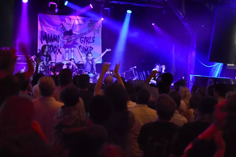 Image: A young band performing in front of a crowd.