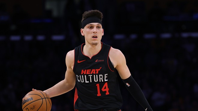 Tyler Herro, clad in a black "Heat Culture" jersey, holding a basketball, and looking fierce
