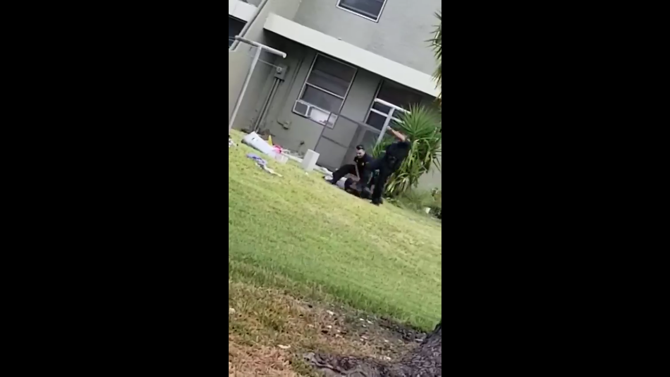 A screenshot of the video showing Officer Mario Figueroa attempting to kick a handcuffed suspect.