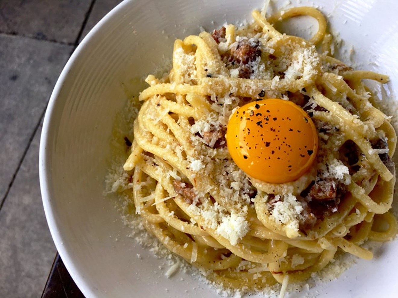 Order bucatini carbonara topped with Parmigiano-Reggiano, black pepper, and an egg yolk during Fooq's Spice brunch.