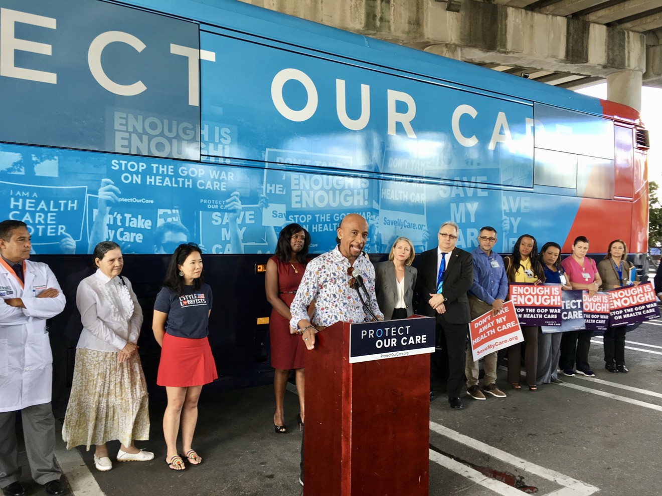 Montel Williams speaks at a Protect Our Care bus event in Miami, along with congressional candidate Mary Barzee Flores, healthcare advocates, and patients.