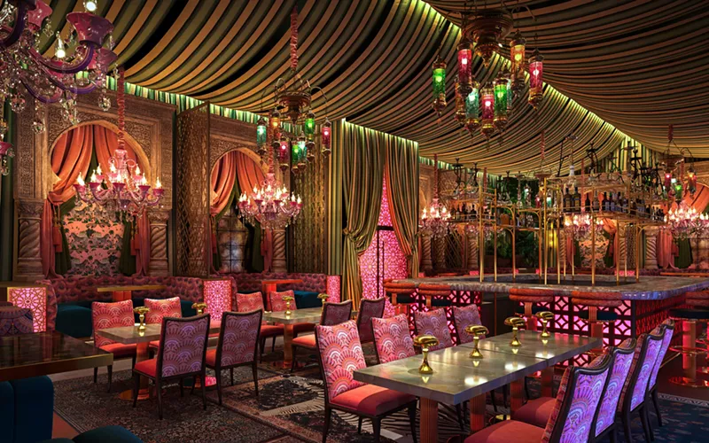 Image: A dimly lit and colorful dining room with pink lighting