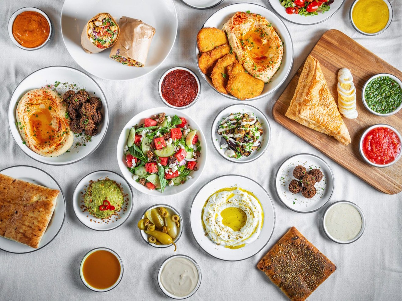 A spread of dishes you'll find on Motek's menu, including falafel, schnitzel, and salads.