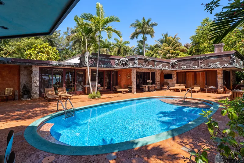 Image: Backyard of Miami Beach house in Morningside. A large oval pool sits in the center.