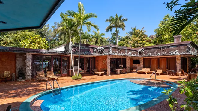 Backyard of Miami Beach house in Morningside. A large oval pool sits in the center.