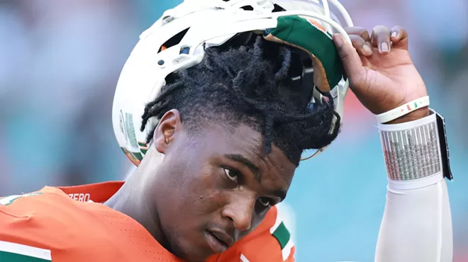 Quarterback Cam Ward #1 of the Miami Hurricanes, looking determined with his helmet tilted back to show his face as he prepares to face Florida A&M Rattlers at Hard Rock Stadium on September 07, 2024