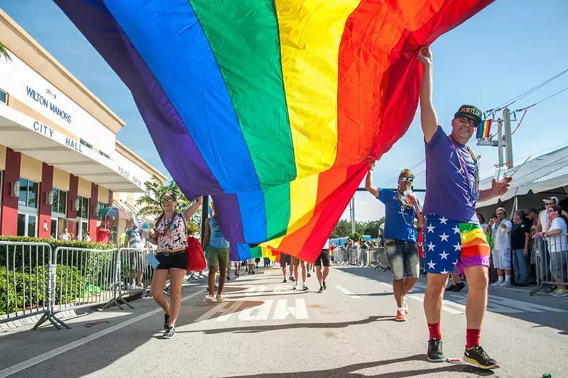 Image: Wilton Manors pride parade participants stroll past city hall.