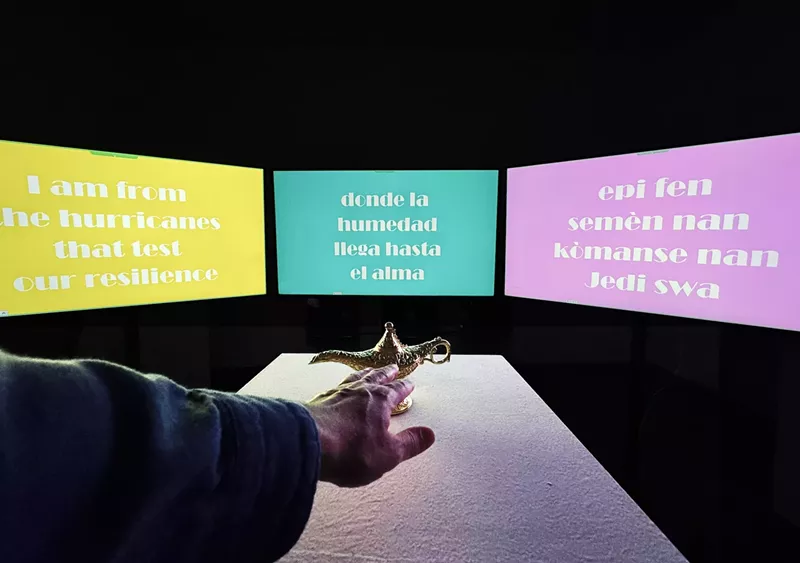 Image: A hand reaching out for a lamp place in front of three screens