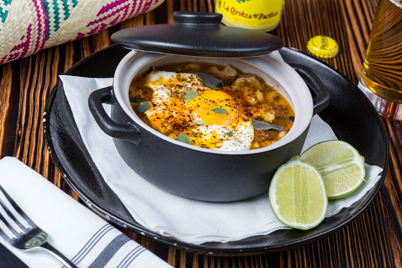 The menudo is a spicy stew topped with a poached egg.