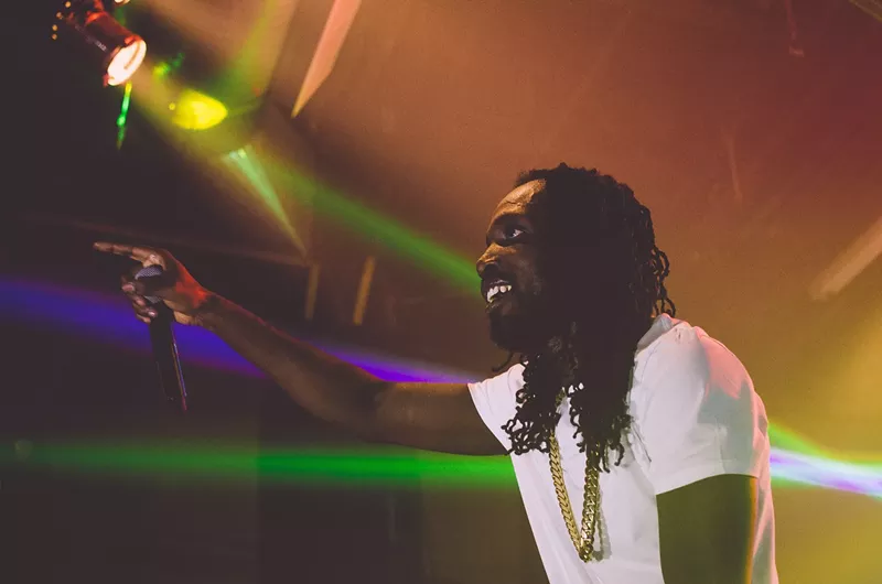 Image: Picture of Jamaican singer Mavado on stage holding a microphone.