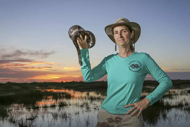 Image: Donna Kalil holds a ball python she caught in the Everglades. She adopted the snake, naming him Benny.
