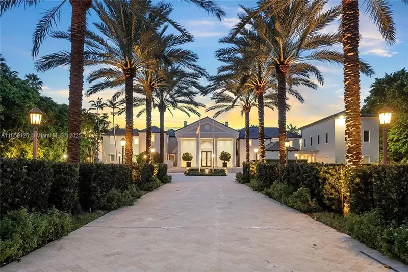 Image: A brick driveway is pictured in the foreground leading to a luxe mansion in Miami Beach.