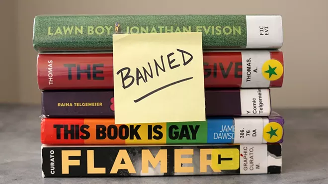 A stack of books frequently found on banned book lists with a sticky note saying "banned"