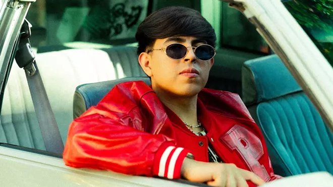 Picture of a young Latin man inside a convertible car wearing sunglasses