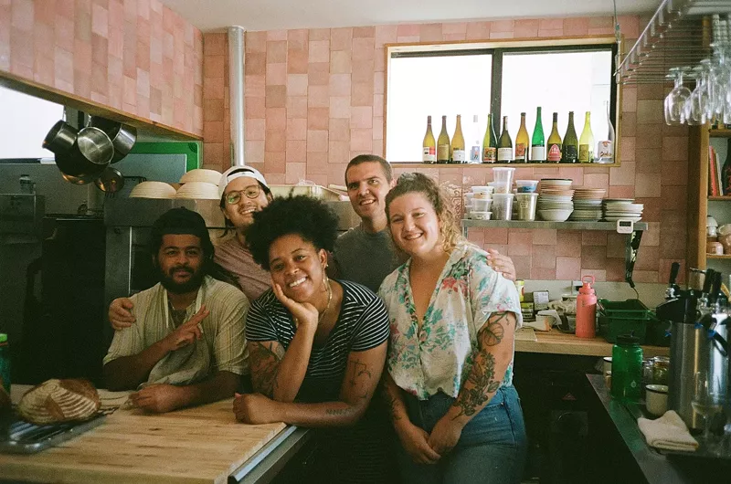 Image: The owners of a restaurant pose for a photo