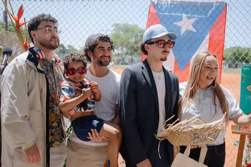 Image: a group of men and a toddler dressed like Bad Bunny