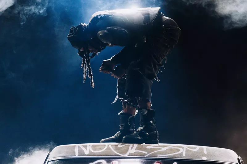 Image: Playboi Carti performing on stage atop the hood of a car